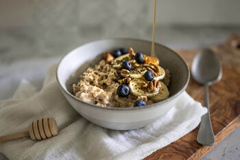 Wärmende Lebensmittel nach TCM: zu sehen ist eine Schale mit Porridge und Chiasamen, Blaubeeren, Walnüssen und Honig