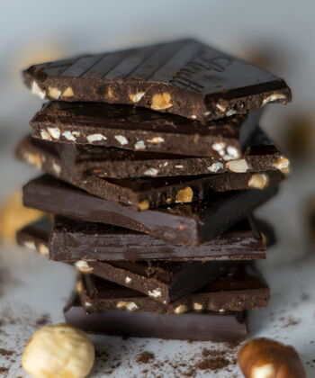 Bitterstoffe in Lebensmitteln: dunkle Schokolade mit Nüssen auf einem Stapel